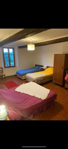 une chambre avec trois lits dans une pièce dans l'établissement Maison de campagne dans le parc régional du Verdon - Bastide 140m2 et Bastidon 85m2, à La Martre