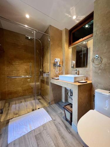 a bathroom with a shower and a toilet and a sink at Nachan The Antique Courtyard in Chiang Khan