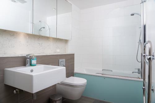 a bathroom with a sink and a toilet and a tub at London Bridge Escape - 2 Bed 2 Bath near landmarks in London