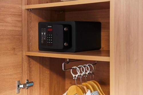 a black microwave oven sitting on top of a shelf at Hotel Restaurant Erber in Ismaning