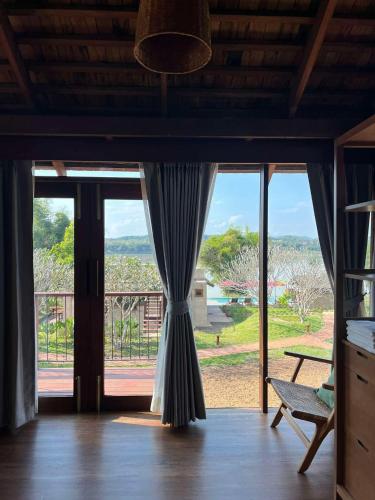 a room with a large glass door with a chair at Nachan The Antique Courtyard in Chiang Khan