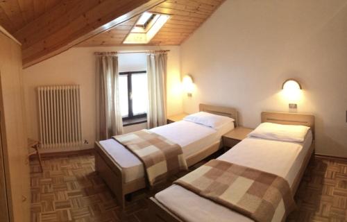 een hotelkamer met drie bedden in een kamer bij Altipiani Trentini in Lavarone