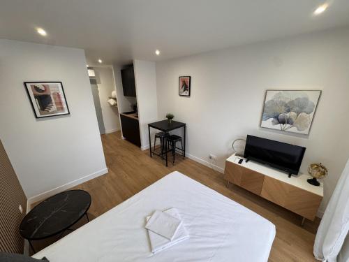 une chambre avec un lit et une télévision dans une pièce dans l'établissement La Résidence République, à Dijon