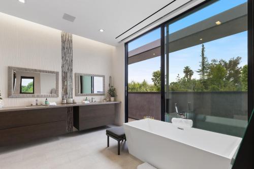 a bathroom with a large tub and a large window at Vanalden in Los Angeles