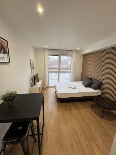 une pièce avec un lit et une table dedans dans l'établissement La Résidence République, à Dijon