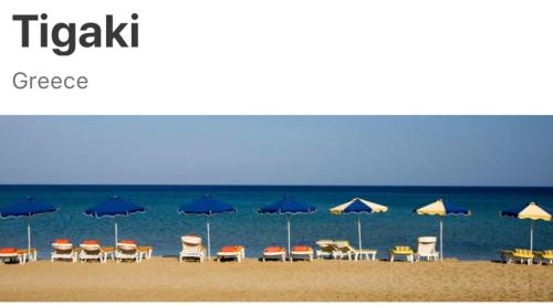 a group of chairs and umbrellas on a beach at XENOS VILLA 7 with a private pool near the sea in Tigaki