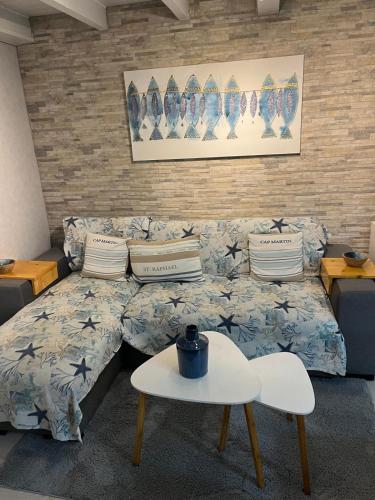 un salon avec un canapé et une table dans l'établissement Le cocon bleu du cap, au Cap d'Agde