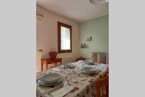 a dining room with a table with plates on it at Green Nest in Farra di Soligo