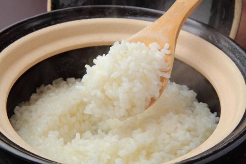 a pot of rice with a wooden spoon in it at Sasara in Gero