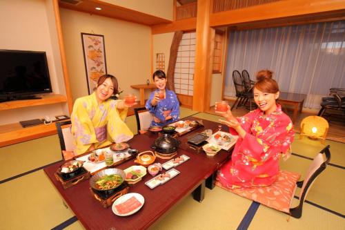 three women sitting around a table eating food at Sasara in Gero
