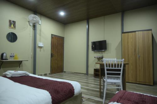a hotel room with a bed and a desk and a chair at Hotel Pohor Regency Near Kamakhya Gate Foot Bridge in Guwahati