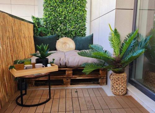 a bench on a patio with plants on it at The ideal place by the sea Mamaia Nord Lidl area in Mamaia Nord