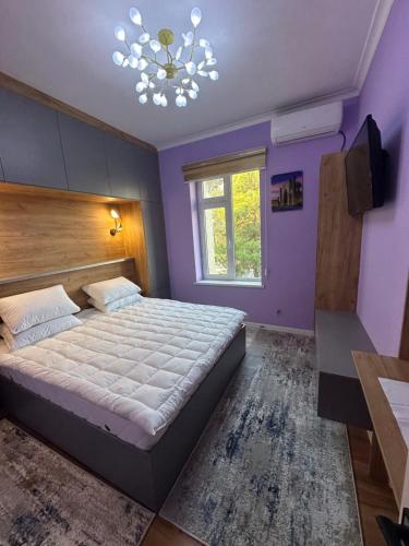 ein Schlafzimmer mit einem großen Bett und einem Kronleuchter in der Unterkunft Apartments with Registan view in Samarkand