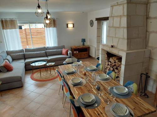 un salon avec une table et une cheminée dans l'établissement Le Colibri, à Chambourg-sur-Indre