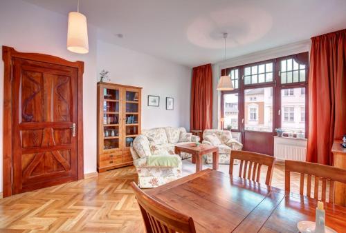 ein Wohnzimmer mit Tisch und Couch in der Unterkunft Ahlbeck, Villa Medici - seitlicher Meerblick in Ahlbeck