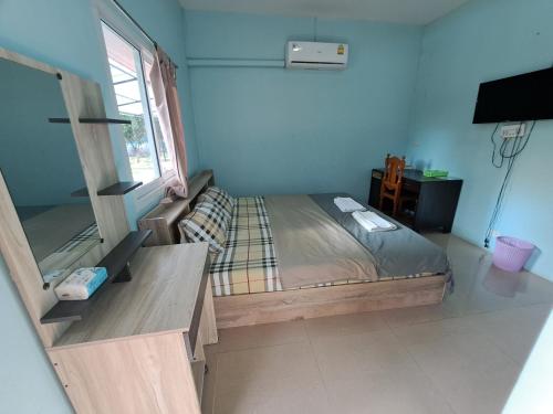 a bedroom with a bed in a room with a window at Armthong Resort in Nakhon Nayok