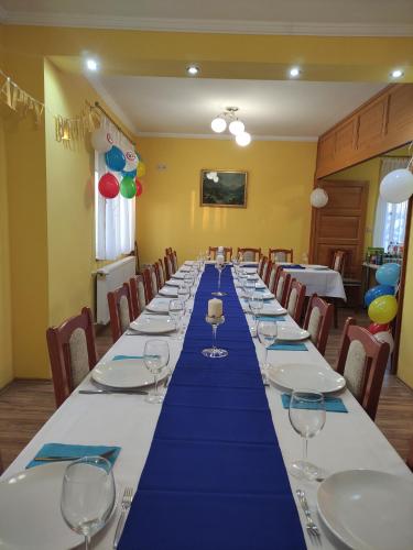 a long table with wine glasses in a room at Orgona Vendégház in Murakeresztúr