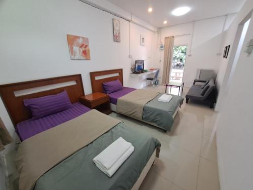 a bedroom with two beds and a desk in it at Armthong Resort in Nakhon Nayok