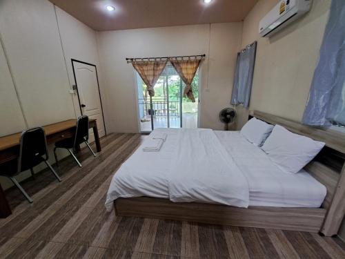 a bedroom with a bed and a desk and a piano at Armthong Resort in Nakhon Nayok
