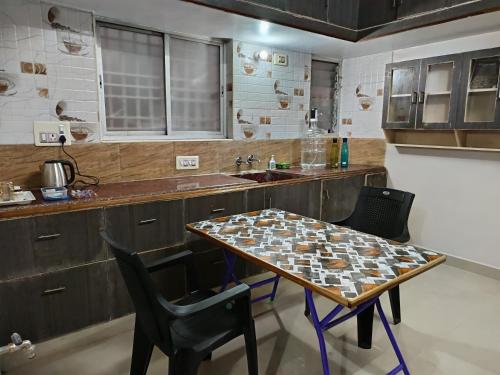 a kitchen with a table and chairs and a sink at Aalaya Darshan Homestay in Tiruvannāmalai