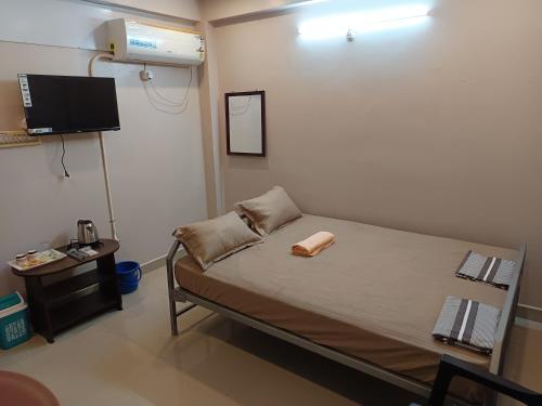 a hospital room with a bed and a flat screen tv at Aalaya Darshan Homestay in Tiruvannāmalai