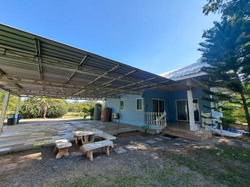 a patio with two picnic tables and a building at Armthong Resort in Nakhon Nayok