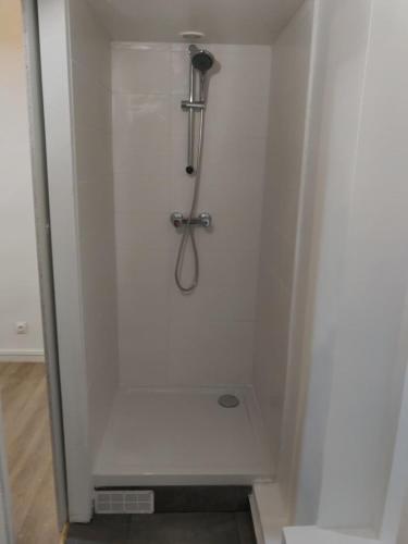 a shower stall in a white wall with a shower at Appartement Savigny - proche Orly in Savigny-sur-Orge