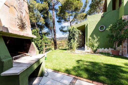 a backyard with a green building and a grass yard at Premium Villa Eleonora, 250m to beach in Fort Village