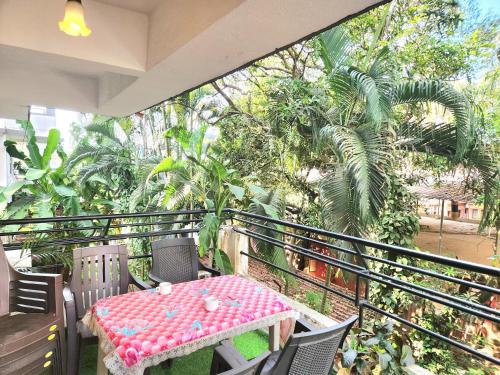 a balcony with a table and chairs and trees at Calangute Beachside Apartment by Welkin stays in Calangute