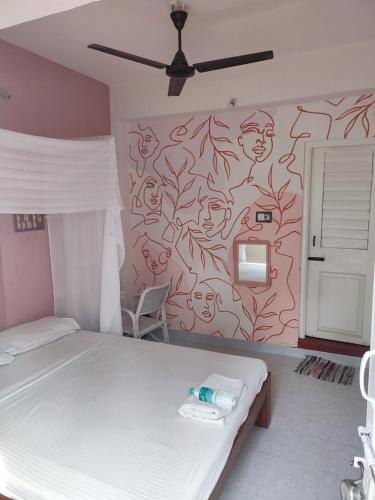 a room with a bed and a wall with a mural at Vanam Pool Stay in Pondicherry