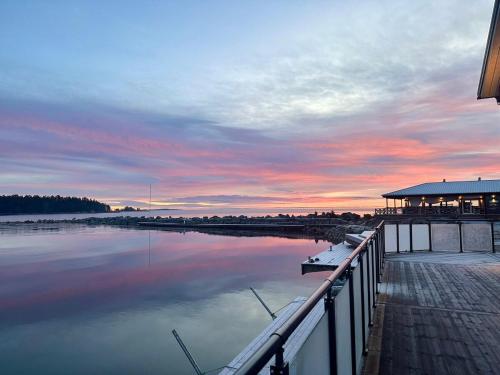 a sunset over a marina with a dock and the water at Comfortable Apartment with private dock in Gnarp