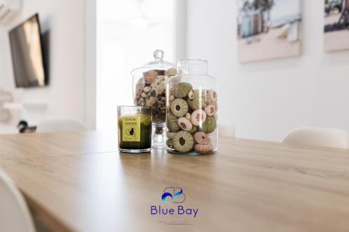 una mesa con dos botellas de vino y una copa en White Bay Beach Apartment, en La Herradura