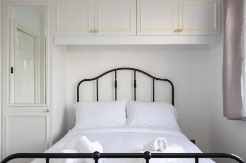 a white bed with a black frame and white pillows at Central Brighton Marina - Apartment - Sleeps 4 in Brighton & Hove