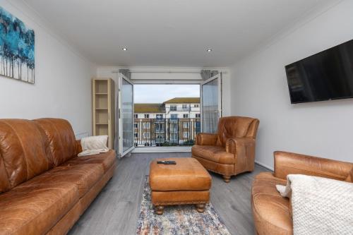 a living room with a couch and two chairs and a television at Central Brighton Marina - Apartment - Sleeps 4 in Brighton & Hove