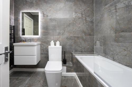 a bathroom with a tub and a toilet and a sink at Central Brighton Marina - Apartment - Sleeps 4 in Brighton & Hove