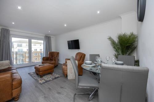 a living room with a glass table and leather chairs at Central Brighton Marina - Apartment - Sleeps 4 in Brighton & Hove