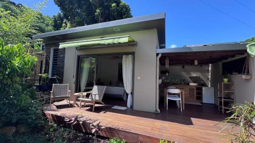a patio with a table and chairs on a deck at Bungalow l'escapade in LʼEntre-Deux