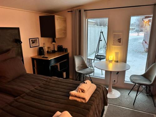 a bedroom with a bed and a table and a window at Guest house - Northern tealight in Rovaniemi