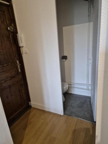 an empty bathroom with a toilet and a door at Le Sixty in Saint-Gaudens