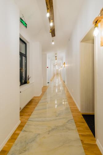 an empty hallway with white walls and wood flooring at Pensiunea Salina Gymnasium in Turda