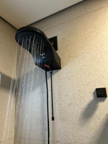 a shower with water coming out of it at Ubatuba Loft Moderno Próximo Praia e Centro Turístico in Ubatuba