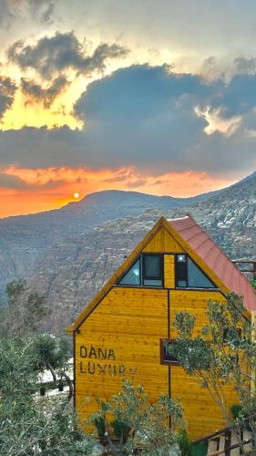 a yellow building with the sunset in the background at Dana luxury huts in Dana