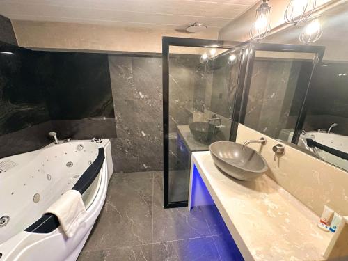 a bathroom with a sink and a tub and a sink at Blue Tulip - 4mins from Mactan Airport in Pusok