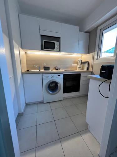 a kitchen with a washing machine and a sink at Studio Residence Du Casino in Menton
