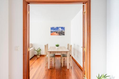 a dining room with a table and a mirror at Apartamentos Alday in Maliaño