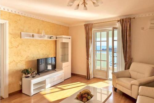 a living room with a couch and a tv at Montesan Luxury Apartments Sveti Stefan in Sveti Stefan