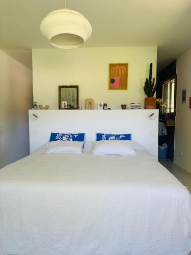 - une chambre avec un grand lit blanc et une tête de lit blanche dans l'établissement House with heated swimming pool and breathtaking views of the Luberon, à Robion