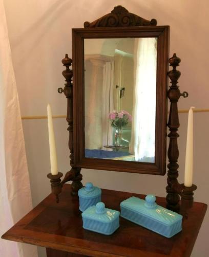 a mirror on a wooden table with two candles at Tenuta Del Gallo in Amelia