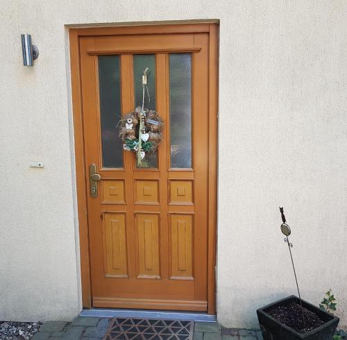 eine Holztür mit einem Kranz darauf in der Unterkunft "Am Prerow Strom" in Prerow