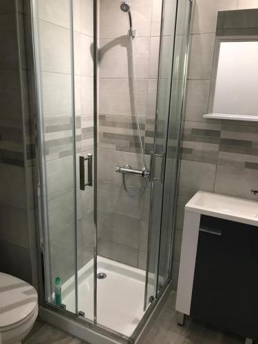 une douche avec une porte vitrée dans une salle de bain dans l'établissement Tamaris Studio, Pool & Beach, à La Seyne-sur-Mer